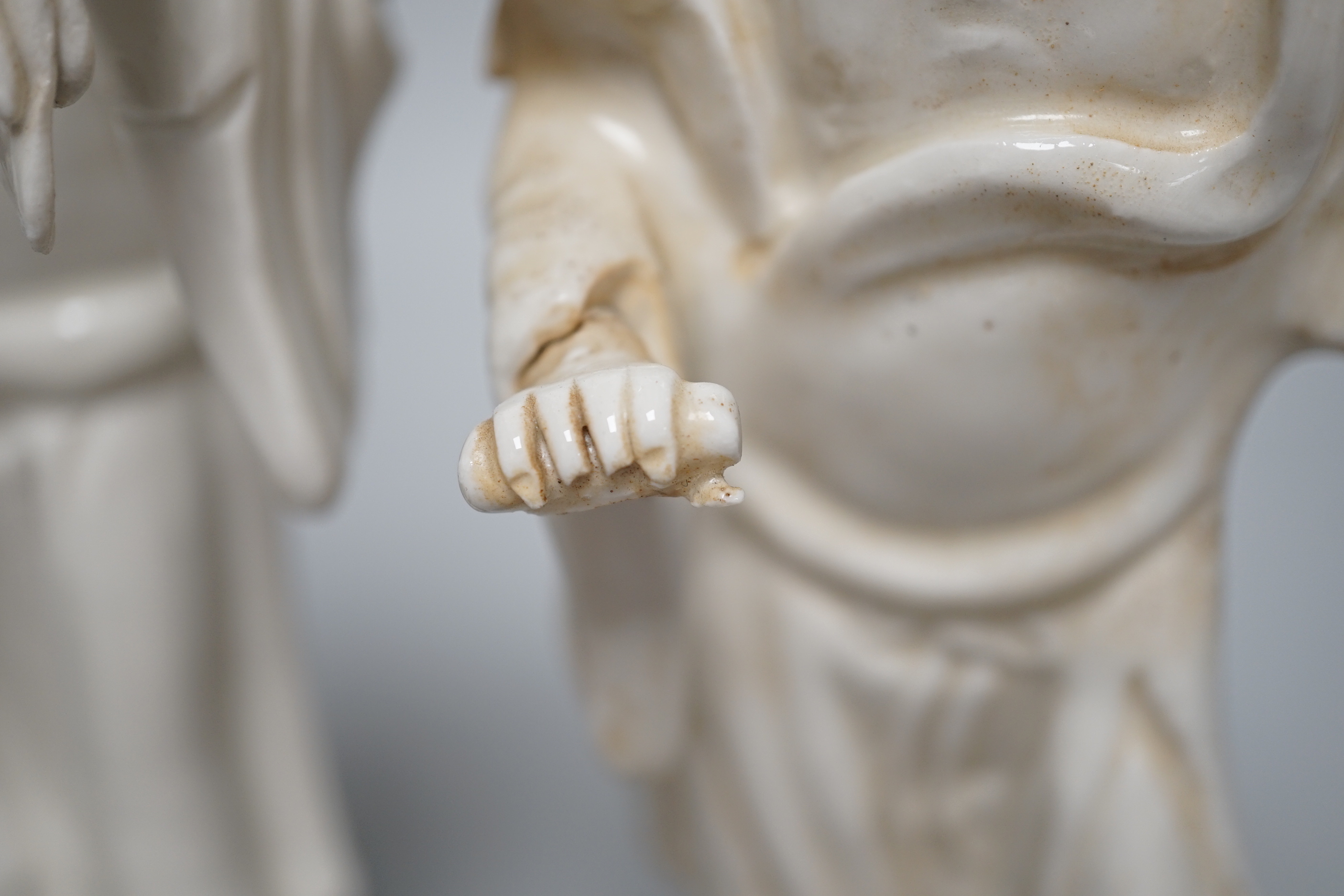 Seven Chinese blanc de Chine figures of immortals, each raised on carved hardwood bases, the largest 24cm high